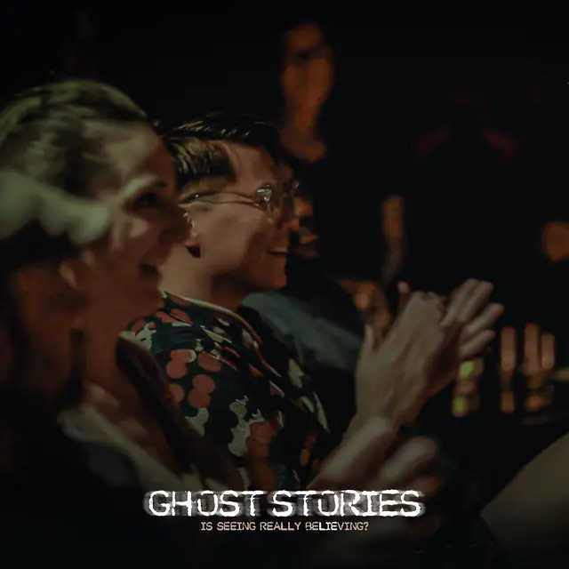 Two guests laughing and applauding in the candlelight