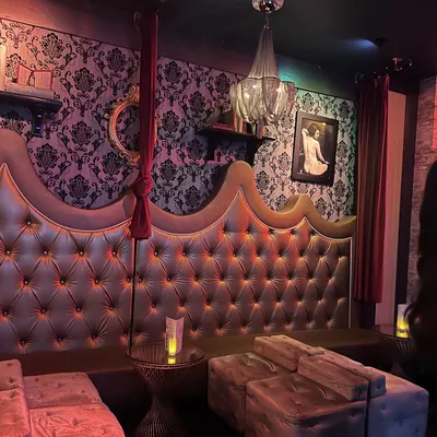Tufted velvet booths beneath damask walls