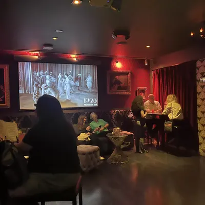 Guests at tables watching the show in the red-lit room