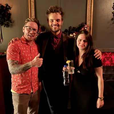 Two guests posing with Kent Axell after the show